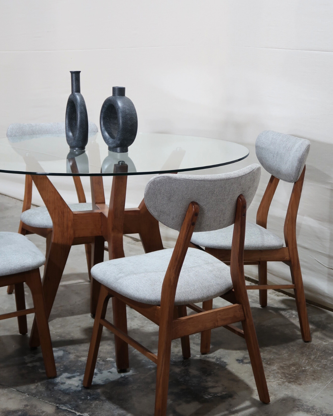 comedor Palermo: diseño moderno Mid-Century con mesa redonda de cubierta de vidrio templado y base de madera sólida. Incluye sillas ergonómicas tapizadas, ideal para espacios sofisticados y duraderos.